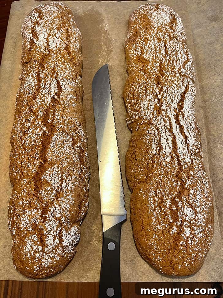 Baked gingerbread biscotti logs removed from the oven, ready for slicing.