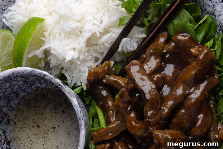 Vietnamese Beef and Watercress Stir Fry (Bo Luc Lac) on a platter with rice and dipping sauce.