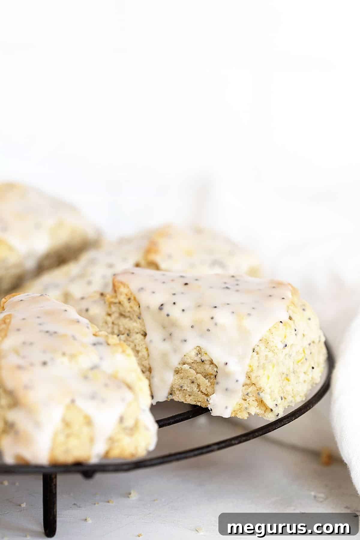 lemon poppy seed scones on cooling rack with glaze
