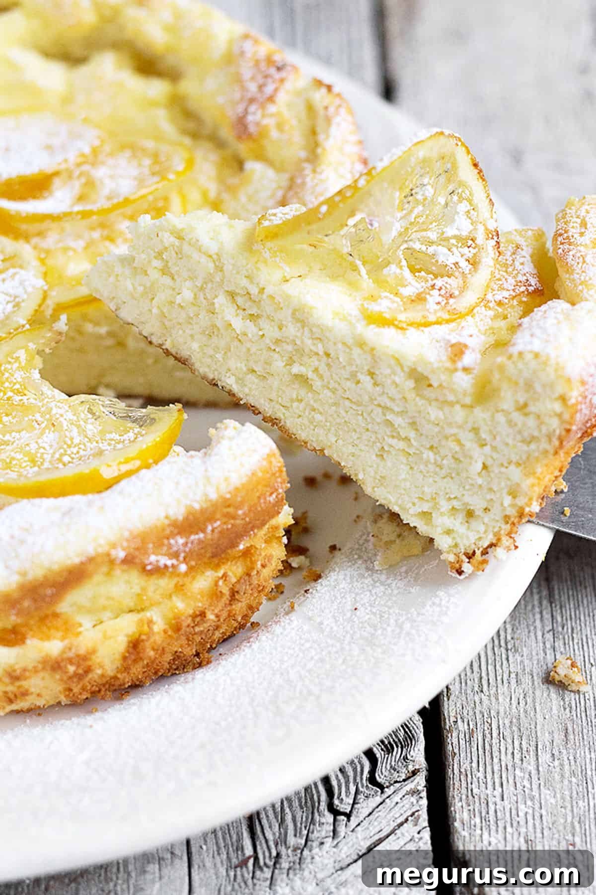 Lemon ricotta cake sliced on a white plate.