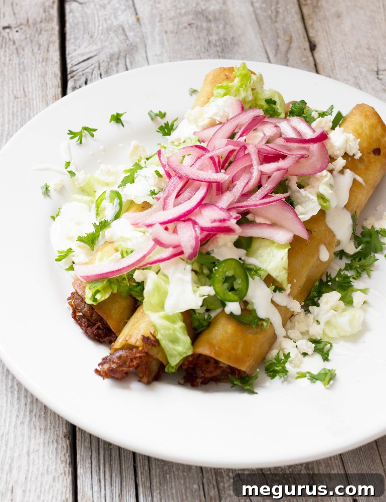 Crispy Carnitas Flautas served on a platter with garnishes