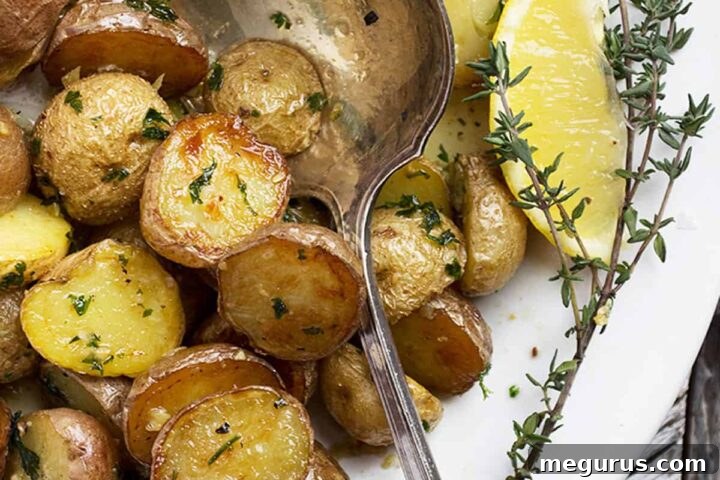 Garlic and Lemon Roasted Potatoes in a serving bowl, garnished.