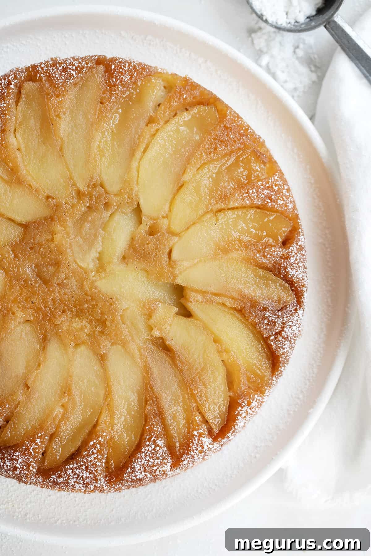 Full maple apple upside down cake on a white serving plate