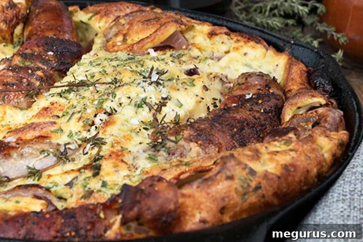 Delicious British Style Toad in the Hole in a cast iron skillet, ready to serve with gravy