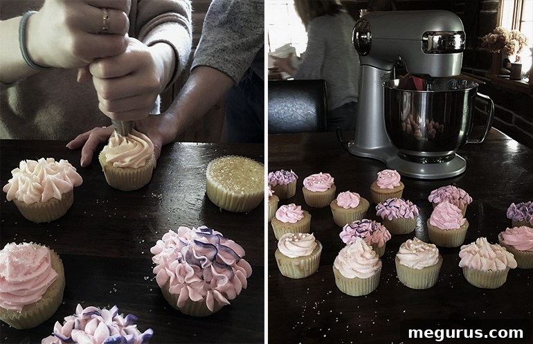 A mother and daughter sharing a heartwarming baking moment while decorating classic vanilla cupcakes