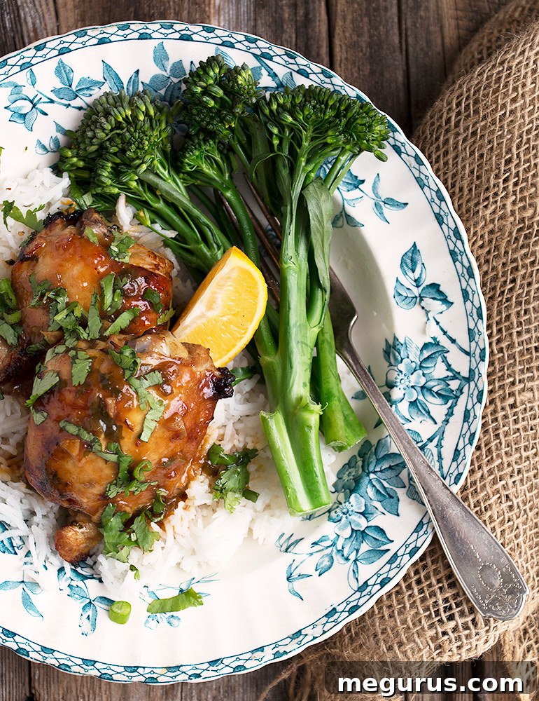 A close-up of golden-brown citrus marinated chicken thighs, garnished with fresh herbs, signifying an easy and delicious weeknight meal.