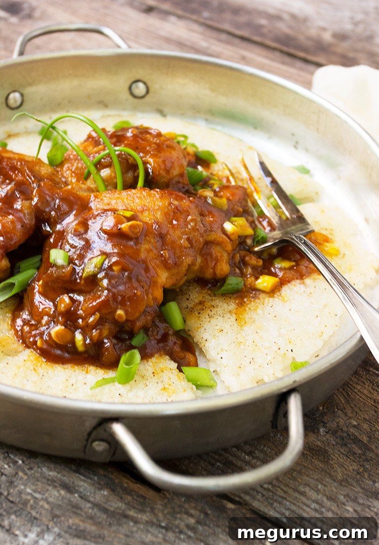 A close-up shot of Spicy Korean Chicken with Crispy Rice, garnished with green onions.