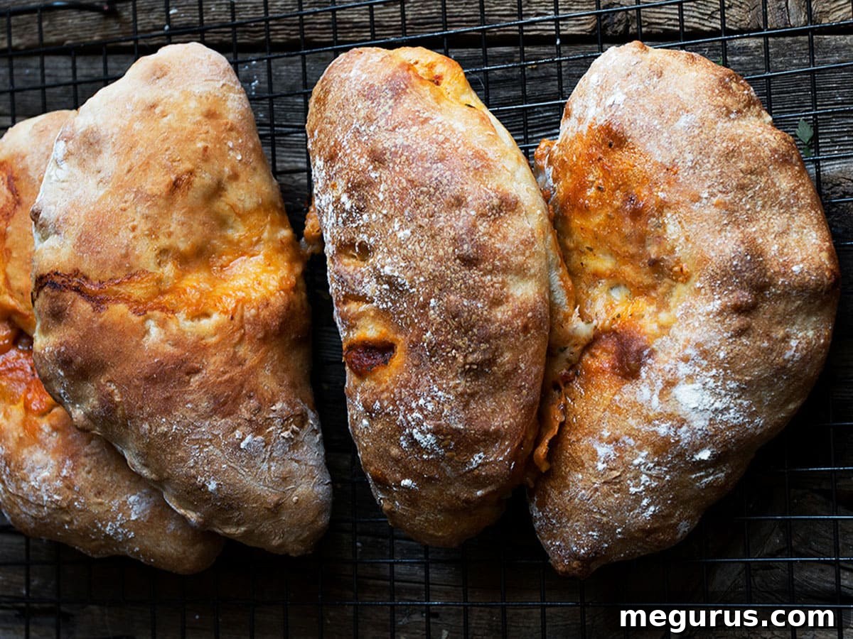 Freshly baked calzones arranged on a dark countertop