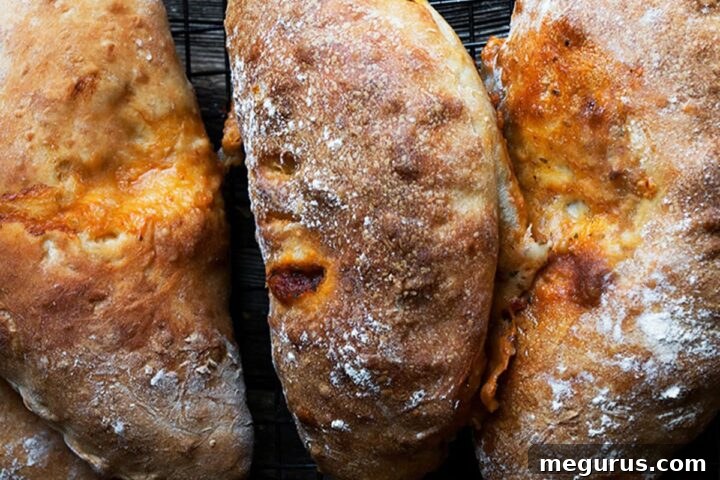 Freshly baked calzones arranged on a dark countertop