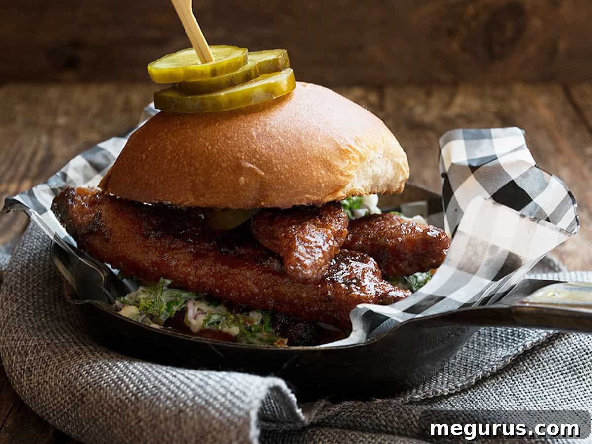 Spicy Nashville Hot Chicken Sandwich on a platter with pickles and coleslaw