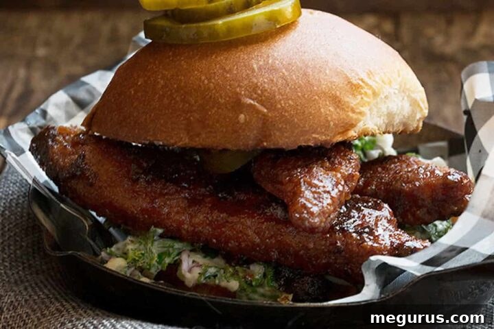 Nashville hot chicken sandwich on platter with pickles and side salad