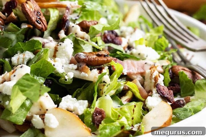 Fall pear chopped salad on white plate with pear behind