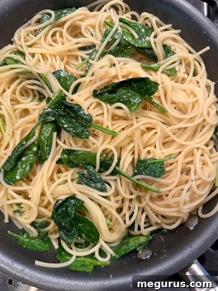 The finished lemon spinach pasta tossed and ready in the skillet.