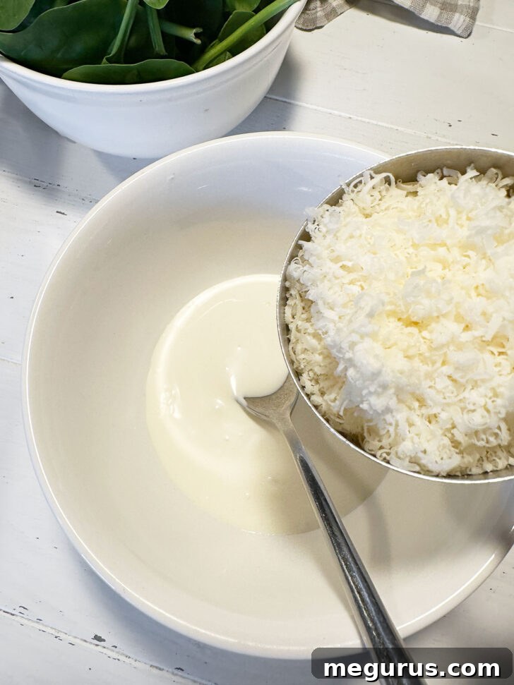 Parmesan cheese being added to a mixing bowl with other sauce ingredients.