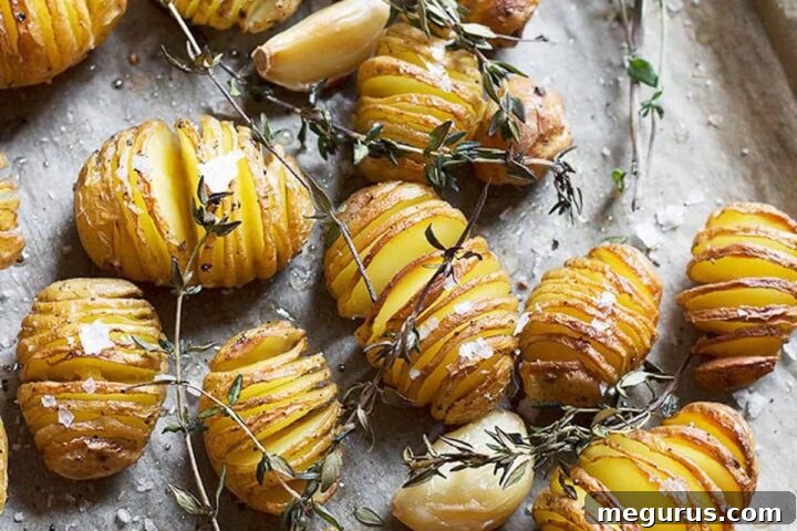 Hasselback mini potatoes roasted to perfection, garnished with fresh thyme.