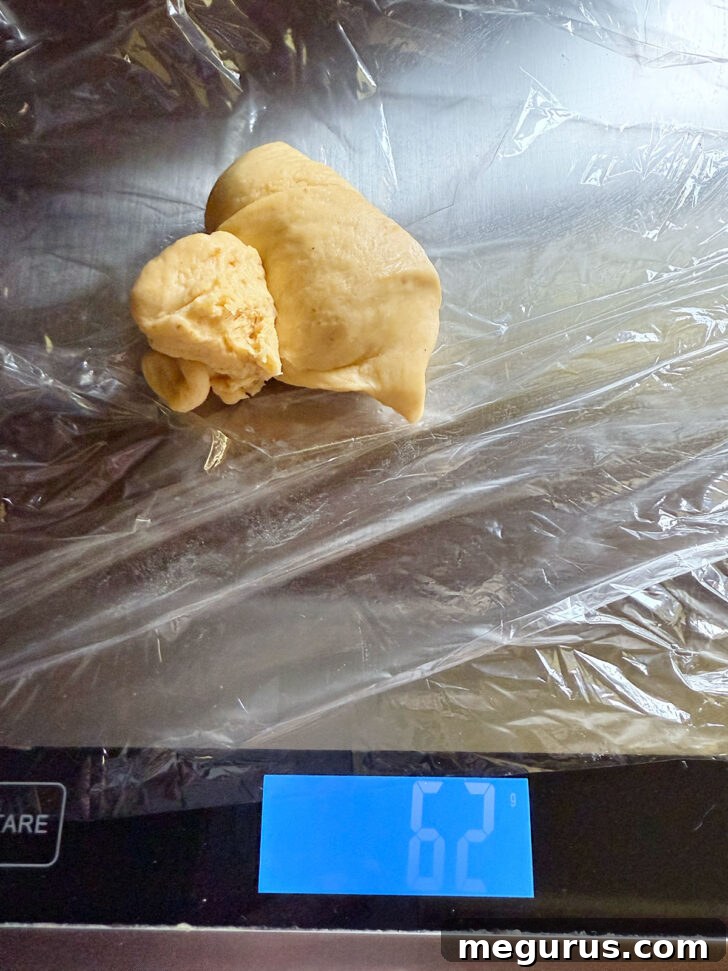 Dividing the dough into individual portions by weighing them on a scale.