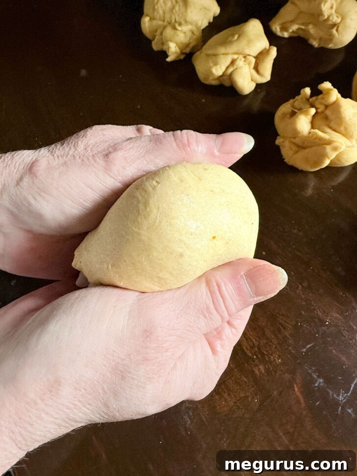 Forming the individual dough pieces into smooth, round balls.