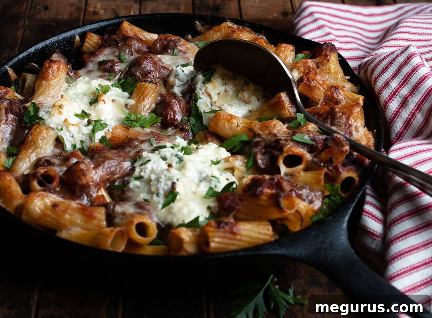 baked pasta with brisket ragu and ricotta in cast iron skillet