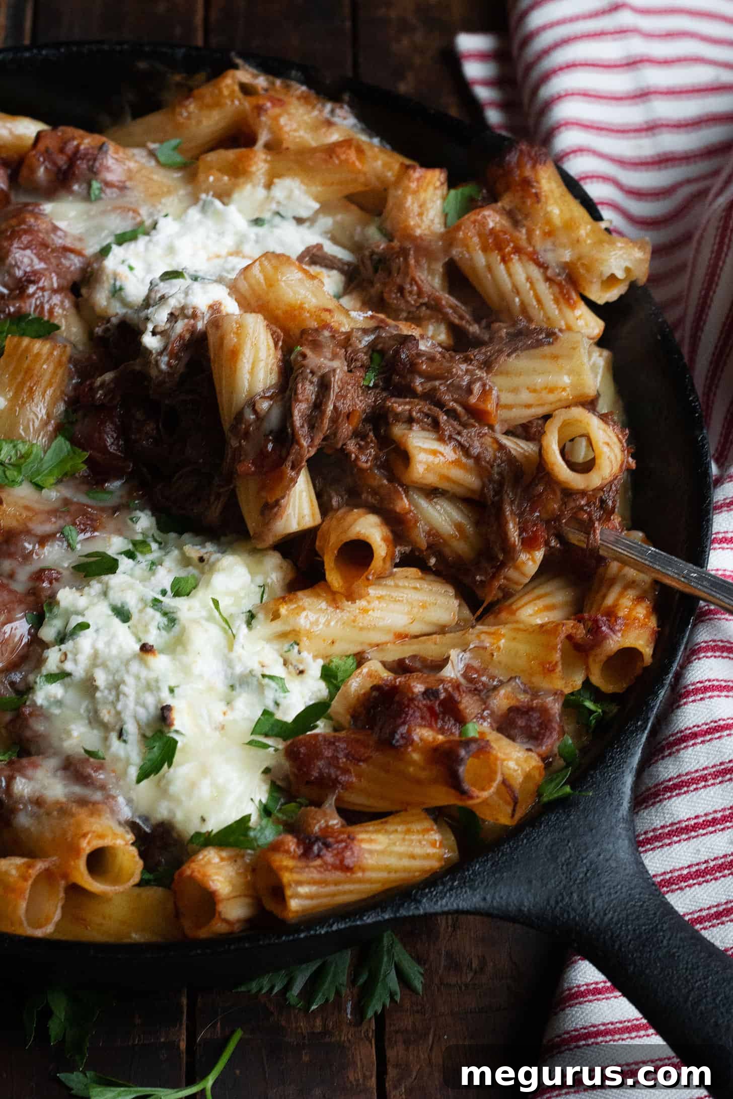 baked pasta with brisket ragu and ricotta in cast iron skillet