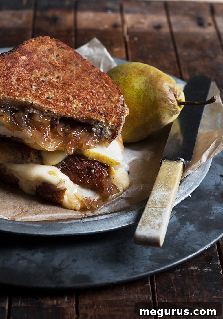 Close-up of a Pear, Gouda and Balsamic Onion Grilled Cheese, showcasing the melted cheese and fillings