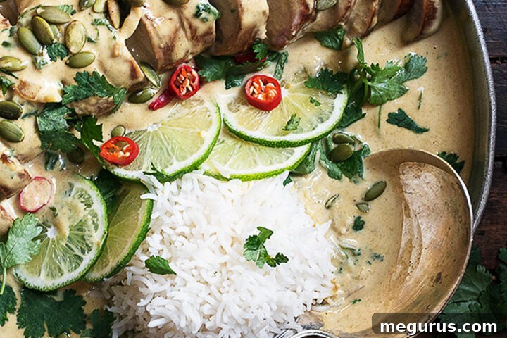 Thai green curry pork tenderloin on platter with limes and rice, ready to serve