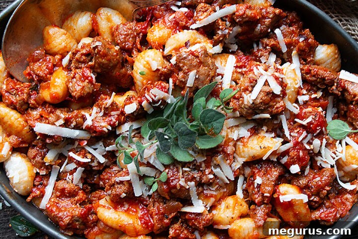 gnocchi with chorizo sausage in serving dish with spoon