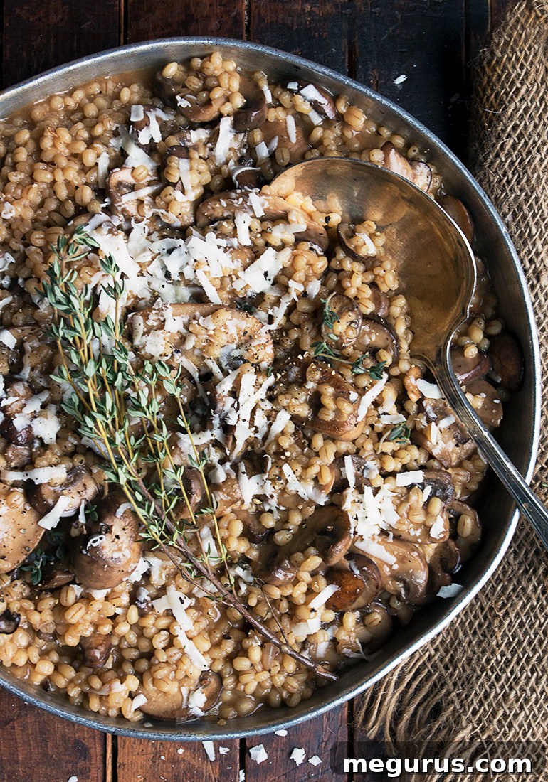 Serving of Mushroom Barley Risotto in a white bowl, garnished with fresh thyme