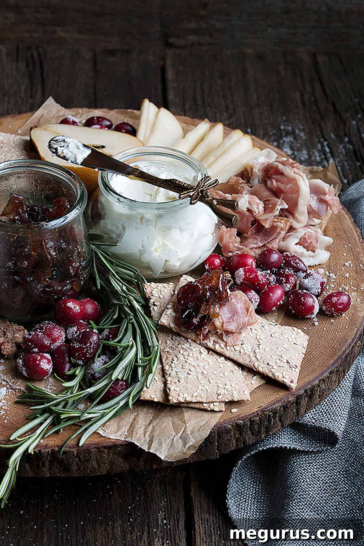 close-up of cranberry charcuterie platter with sugared cranberries and rosemary