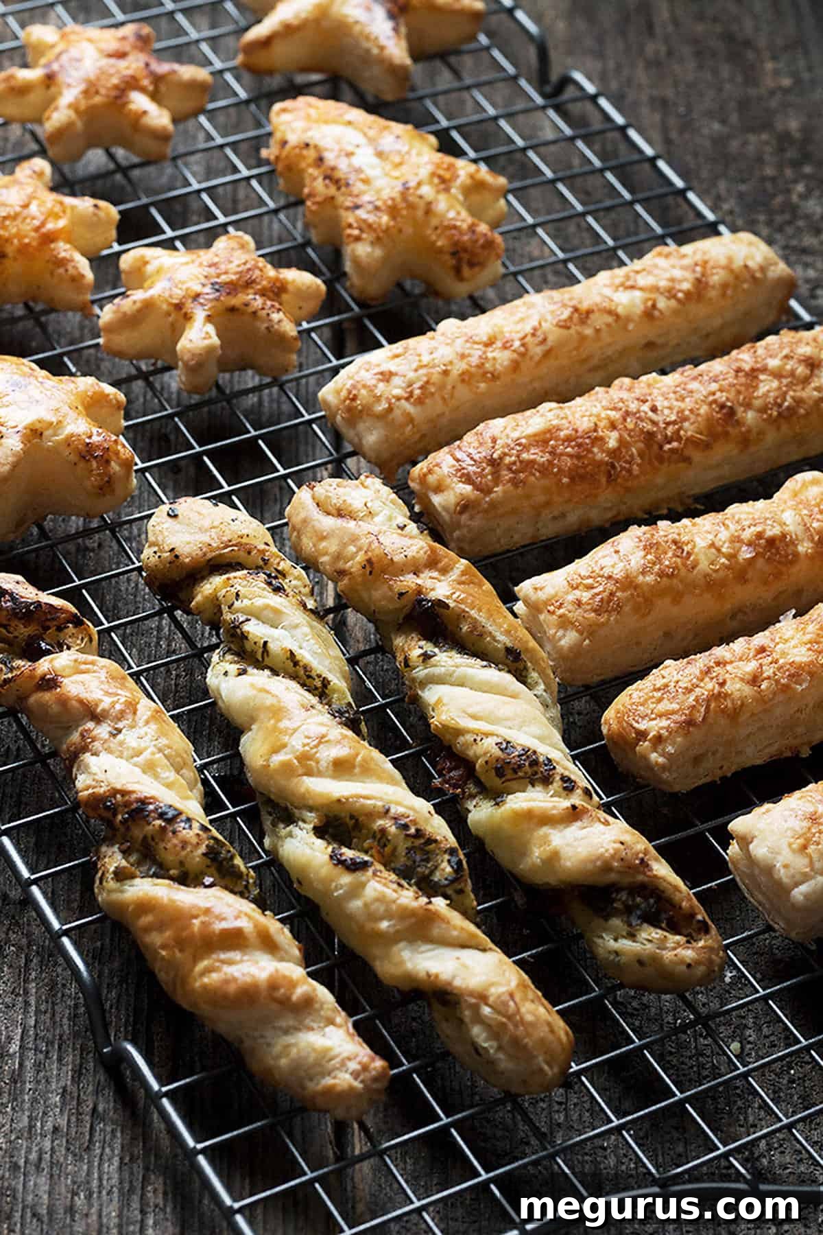 Close-up of baked puff pastry appetizers, golden brown and perfectly puffed, cooling on a rack.
