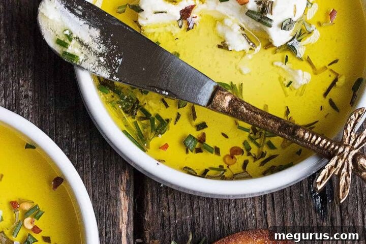 Marinated goat cheese in small white bowls with a knife, ready for serving