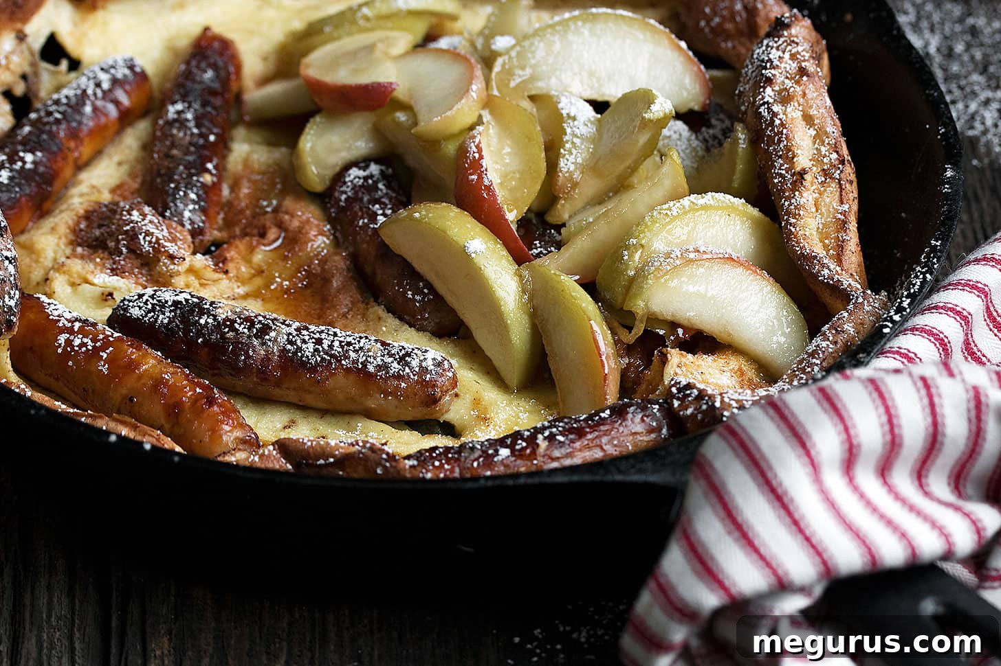 Sausage Dutch Baby pancake with apples in skillet