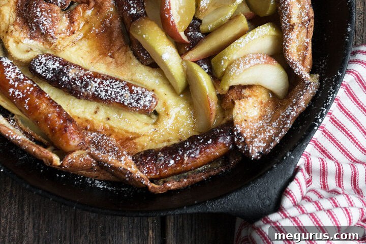 Sausage Dutch Baby pancake with apples in skillet