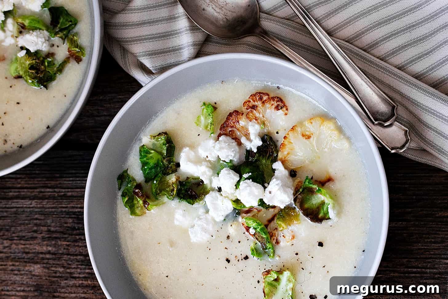 cauliflower potato soup in bowl with goat cheese crumbles