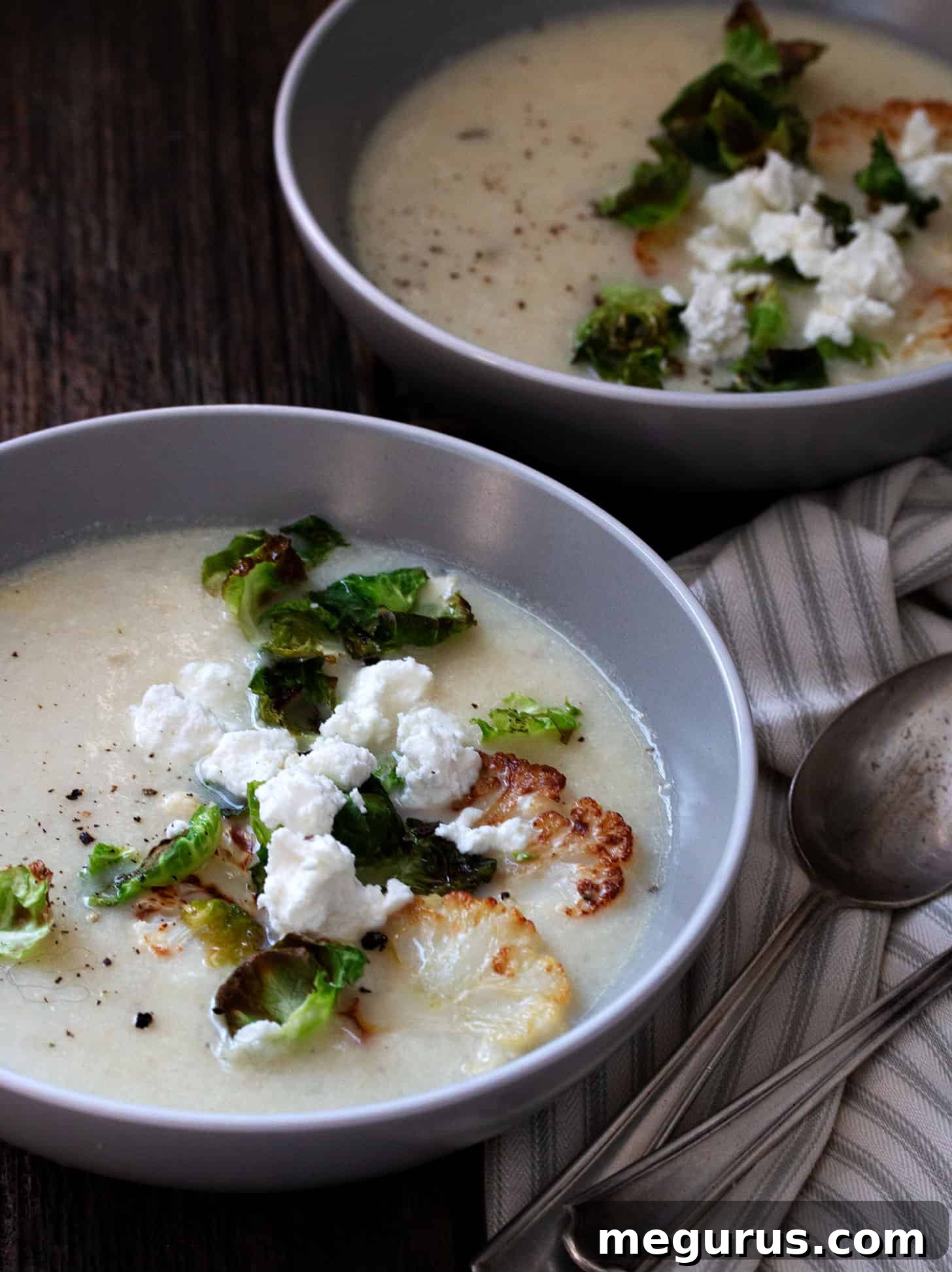 cauliflower potato soup in bowl with goat cheese crumbles