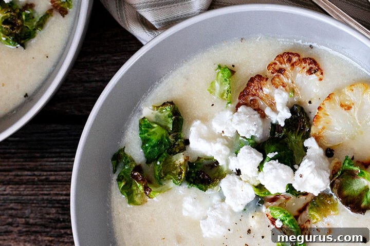cauliflower potato soup in bowl with goat cheese crumbles