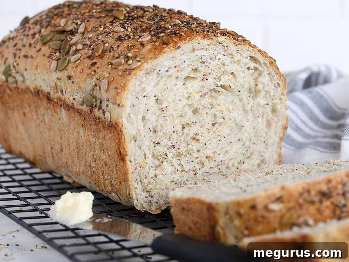 Seeded multigrain bread sliced on a cooling rack, showcasing its light texture and wholesome grains.