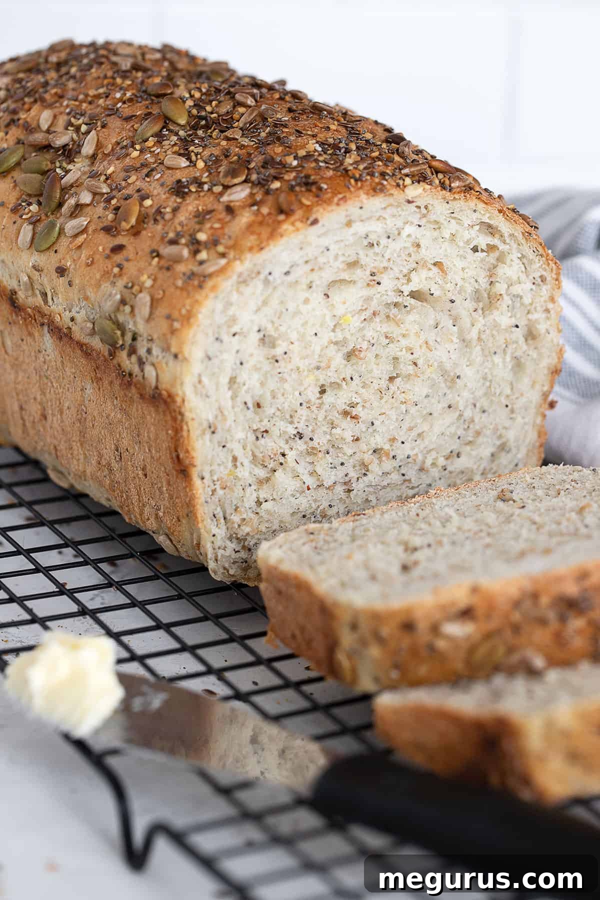 Freshly baked seeded multigrain bread, perfectly sliced and arranged on a wire cooling rack.