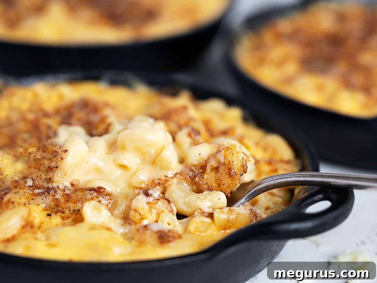creamy mac and cheese in cast iron skillets with fork