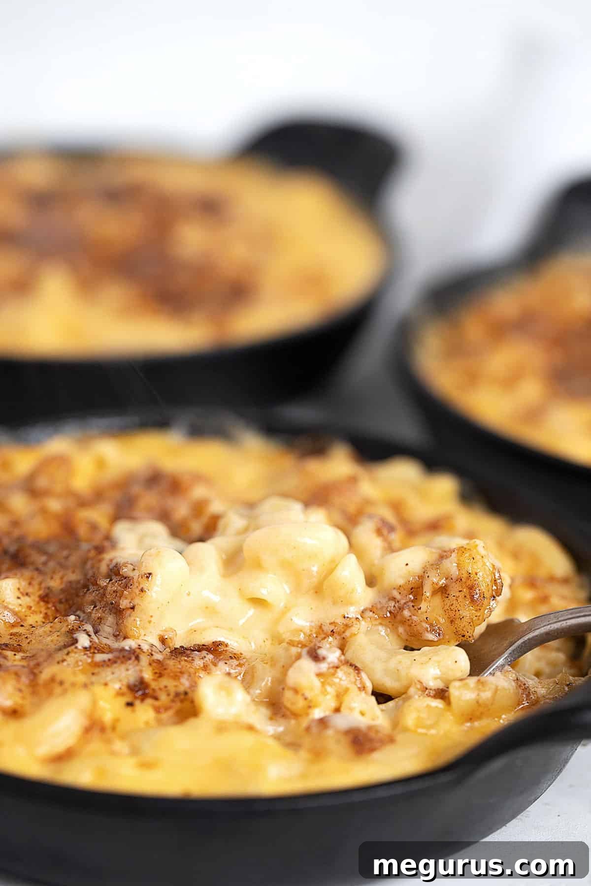 creamy mac and cheese in cast iron skillets with fork