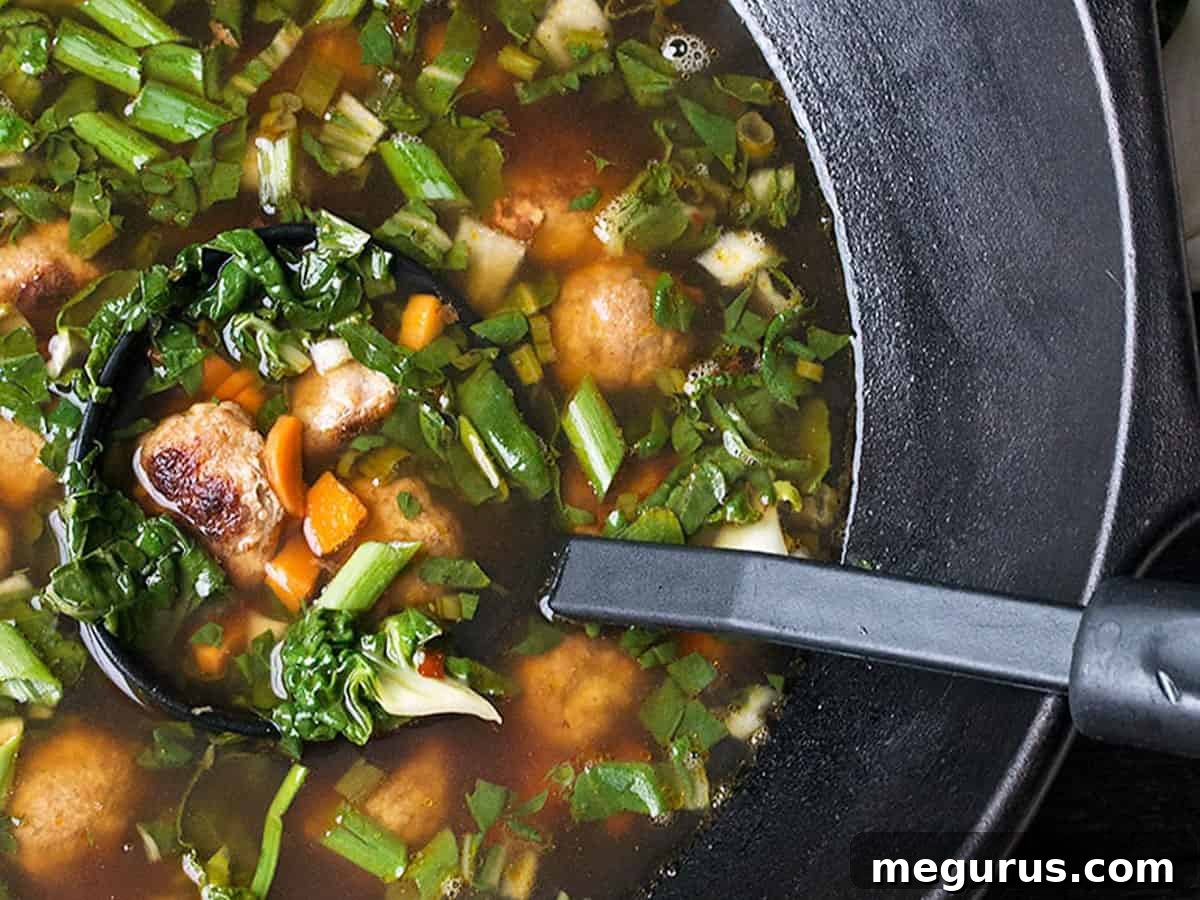 Asian-inspired pork meatball soup with bok choy in cast iron wok