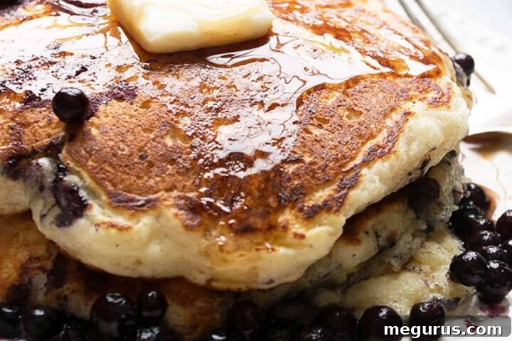 Stack of buttermilk blueberry pancakes on a plate, ready to be served.
