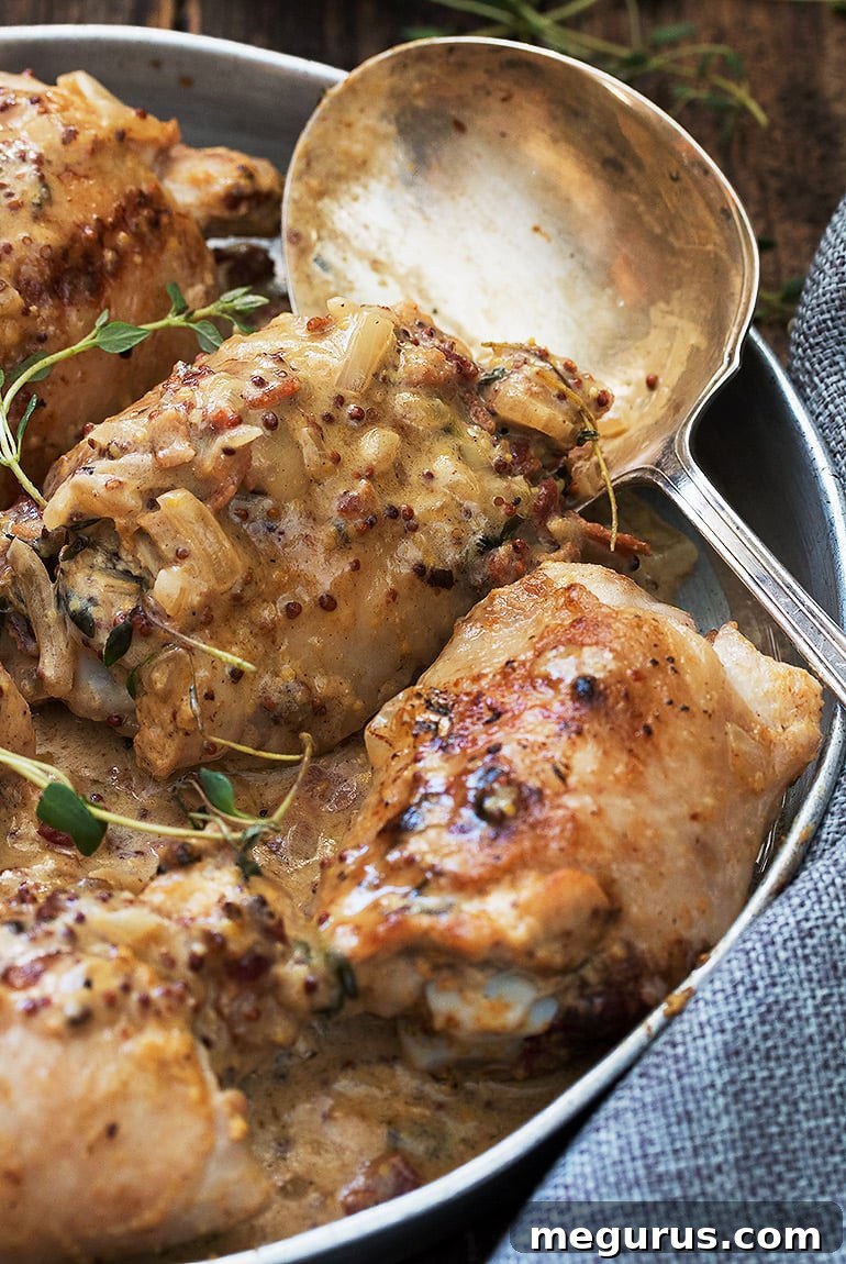 Close-up shot of cooked Chicken with Dijon Mustard Sauce garnished with fresh thyme.