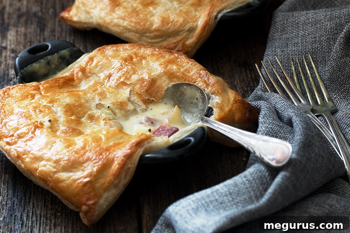 Two individual corned beef and cabbage pot pies topped with golden puff pastry