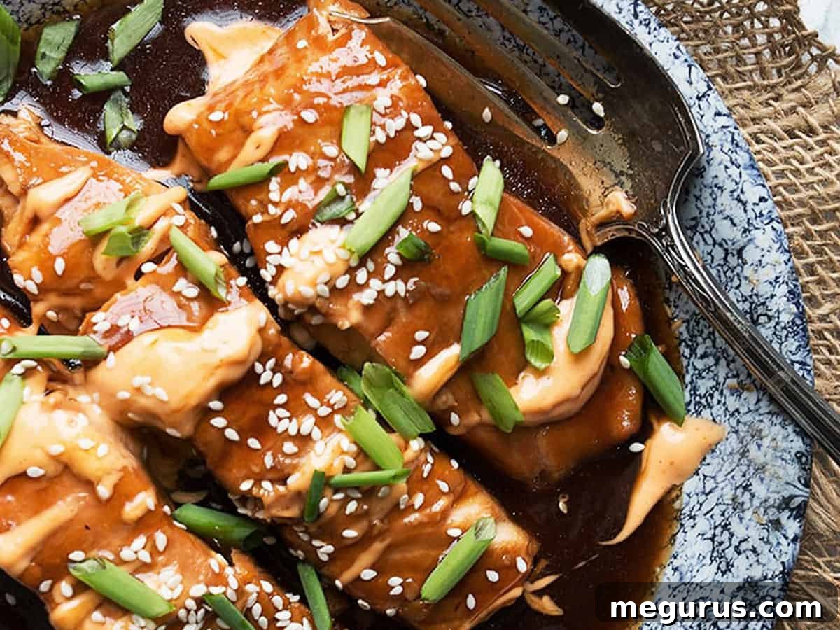 Instant Pot Teriyaki Salmon served with rice and broccoli, drizzled with Sriracha mayo, on a rustic platter.