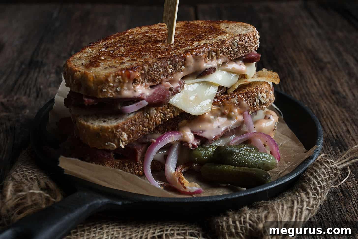 Classic Grilled Reuben Sandwich with a side of pickles, showcasing golden-brown bread and melted cheese