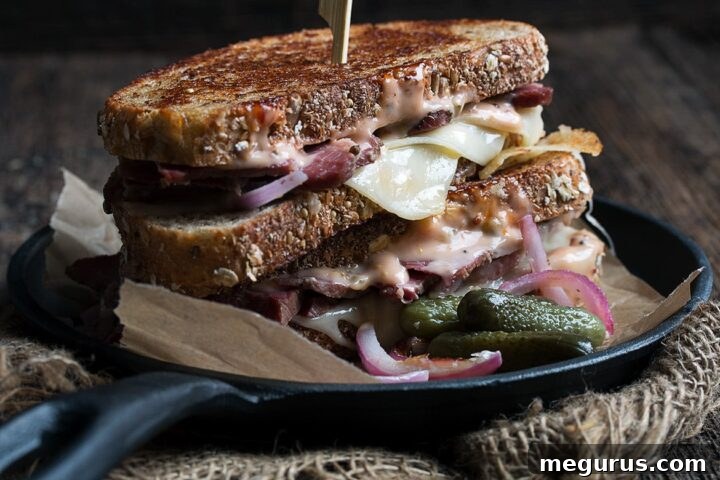 Reuben sandwich grilling on a cast iron skillet, showing the golden crust
