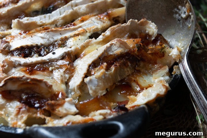 Tartiflette with golden cheese topping in a cast iron skillet.