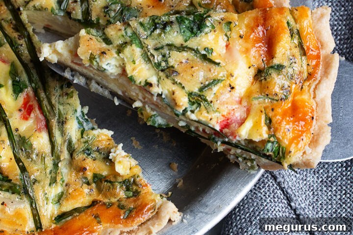 A vibrant close-up of a slice of crab quiche, showcasing the rich filling and golden crust