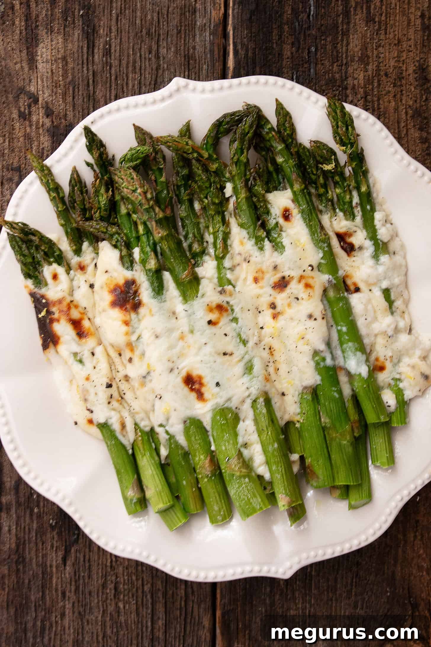 Asparagus cacio e pepe on a white serving platter.