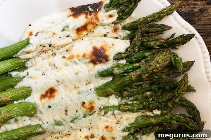 Asparagus cacio e pepe on a white serving platter.
